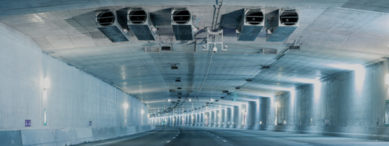 A brightly lit tunnel with an installed ventilation system in the ceiling